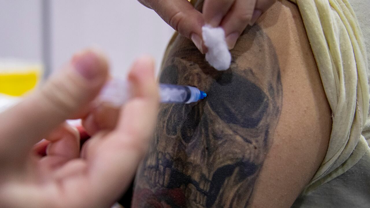 Un trabajador de la salud prepara inyecta a un estudiante una dosis de la vacuna CanSino COVID-19 en un sitio de vacunación en el campus de la Universidad Andrés Bello, en Santiago, Chile, el jueves 3 de junio de 2021. (Foto AP / Esteban Felix)