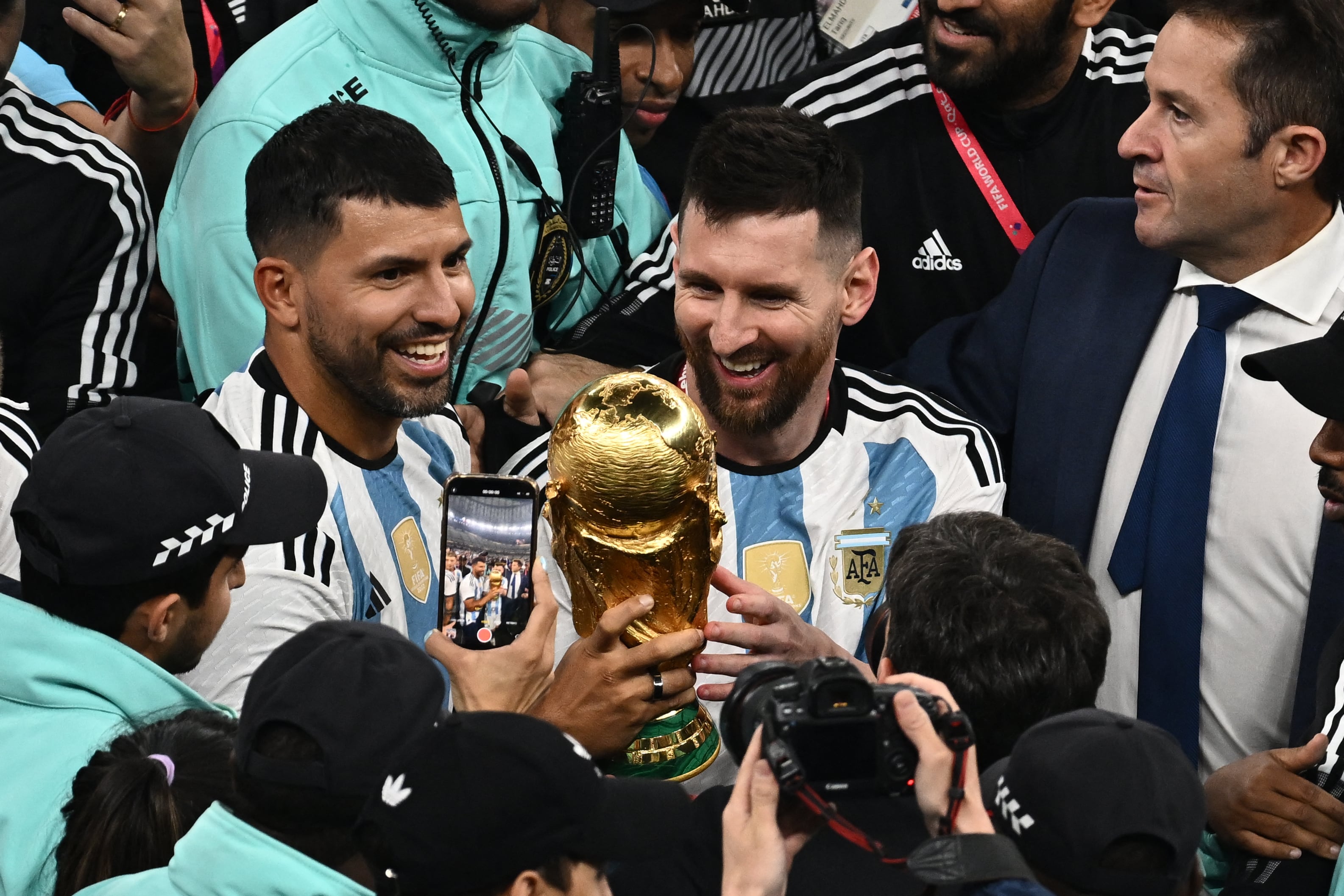 Argentina's forward #10 Lionel Messi celebrates with teammates holding the World Cup Trophy at the end of the Qatar 2022 World Cup final football match between Argentina and France at Lusail Stadium in Lusail, north of Doha on December 18, 2022. (Photo by Jewel SAMAD / AFP)