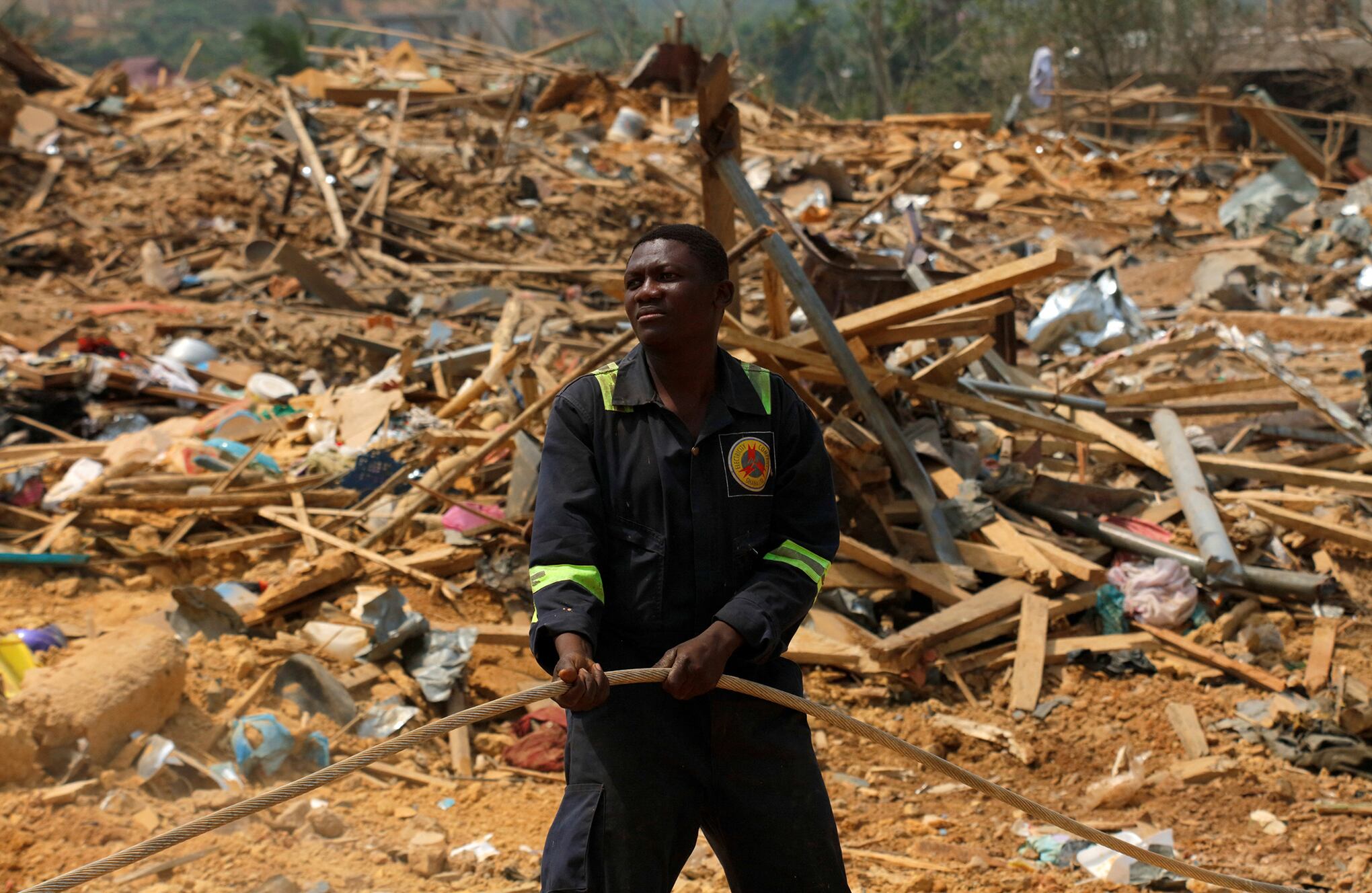 La gente observa los daños causados cuando un vehículo que transportaba explosivos mineros detonó a lo largo de una carretera en Apiate, Ghana. Foto REUTERS/Francis Kokoroko