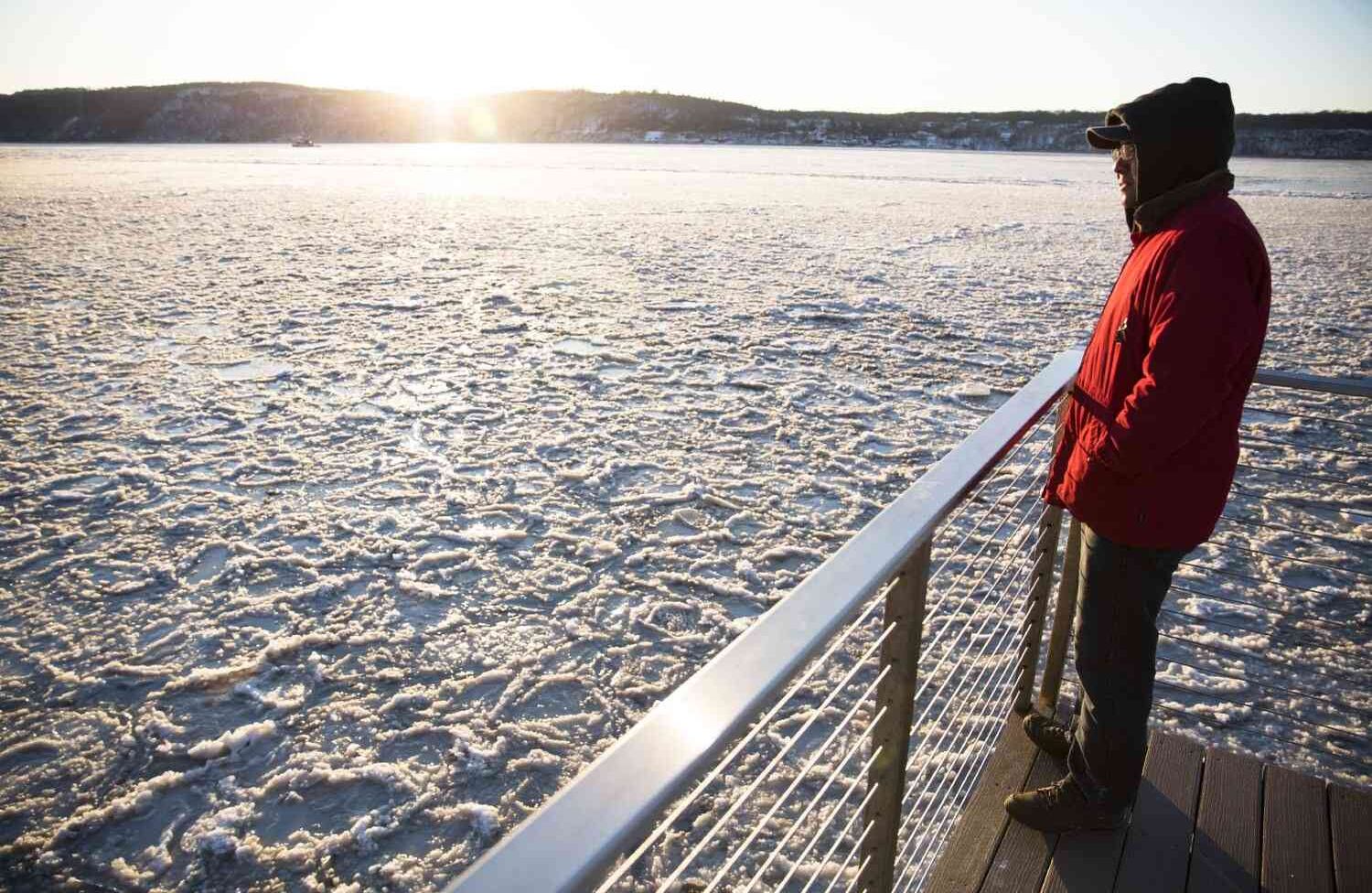DOBBS FERRY, NY : Un hombre se encuentra en una cubierta cerca del río Hudson congelado el 5 de enero de 2018 en Dobbs Ferry, Nueva York. Se esperan temperaturas extremas y viento durante el fin de semana en el noreste. Amir Levy / Getty Images / AFP