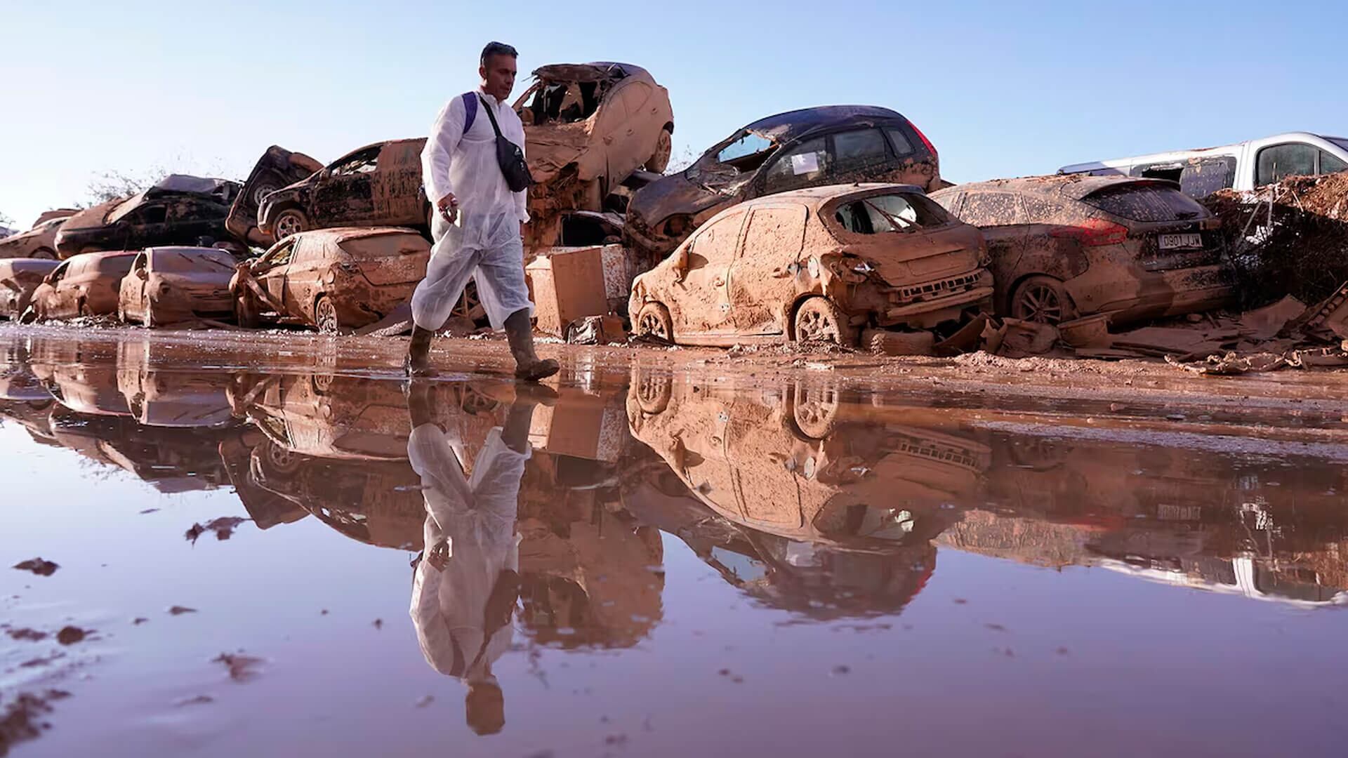 Un hombre camina junto a autos amontonados después de las inundaciones en Catarroja que dejaron cientos de muertos o desaparecidos en la región de Valencia, España.