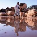 Un hombre camina junto a autos amontonados después de las inundaciones en Catarroja que dejaron cientos de muertos o desaparecidos en la región de Valencia, España.