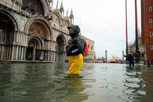La gente se abre paso a través del agua en la inundada Plaza de San Marcos luego de una marea alta, en Venecia, Italia, el martes 8 de diciembre de 2020. Las mareas altas inundaron la Plaza de San Marcos en Venecia el domingo, impulsadas por vientos más fuertes de lo previsto, por lo que no se pudo activar el nuevo sistema de barreras inflables para evitar que el agua invada la ciudad de la laguna. Foto: Anteo Marinoni / LaPresse vía AP.