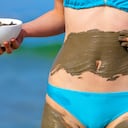 Woman smearing mud mask on the body