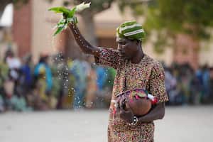 Un hombre rocía agua durante el Festival Anual del Vudú en Ouidah, Benín, el 9 de enero de 2025. (AP Foto/Sunday Alamba)