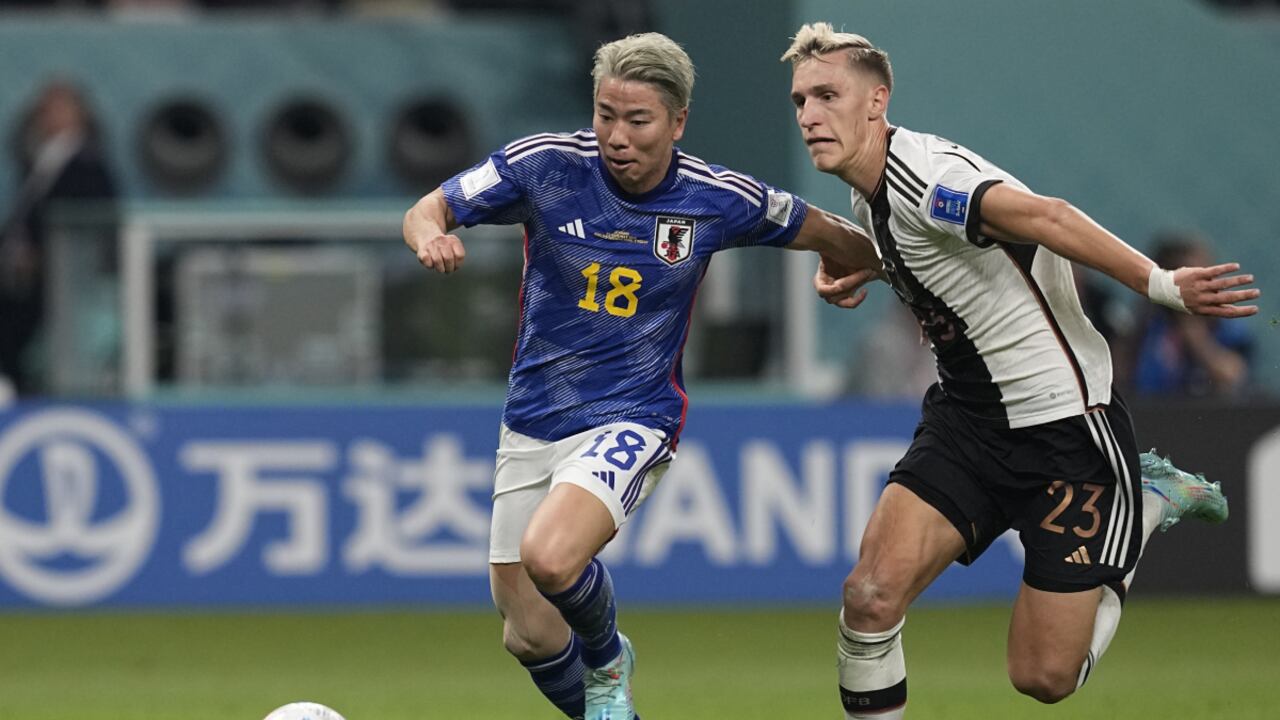 Japan's Takuma Asano, left, fight for the ball with Germany's Nico Schlotterbeck, on his way to score his side's second goal during the World Cup group E soccer match between Germany and Japan, at the Khalifa International Stadium in Doha, Qatar, Wednesday, Nov. 23, 2022. (AP/Ebrahim Noroozi)