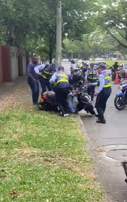 Motociclista en Cali se opone a tres agentes de tránsito tras recibir una multa por no tener licencia.