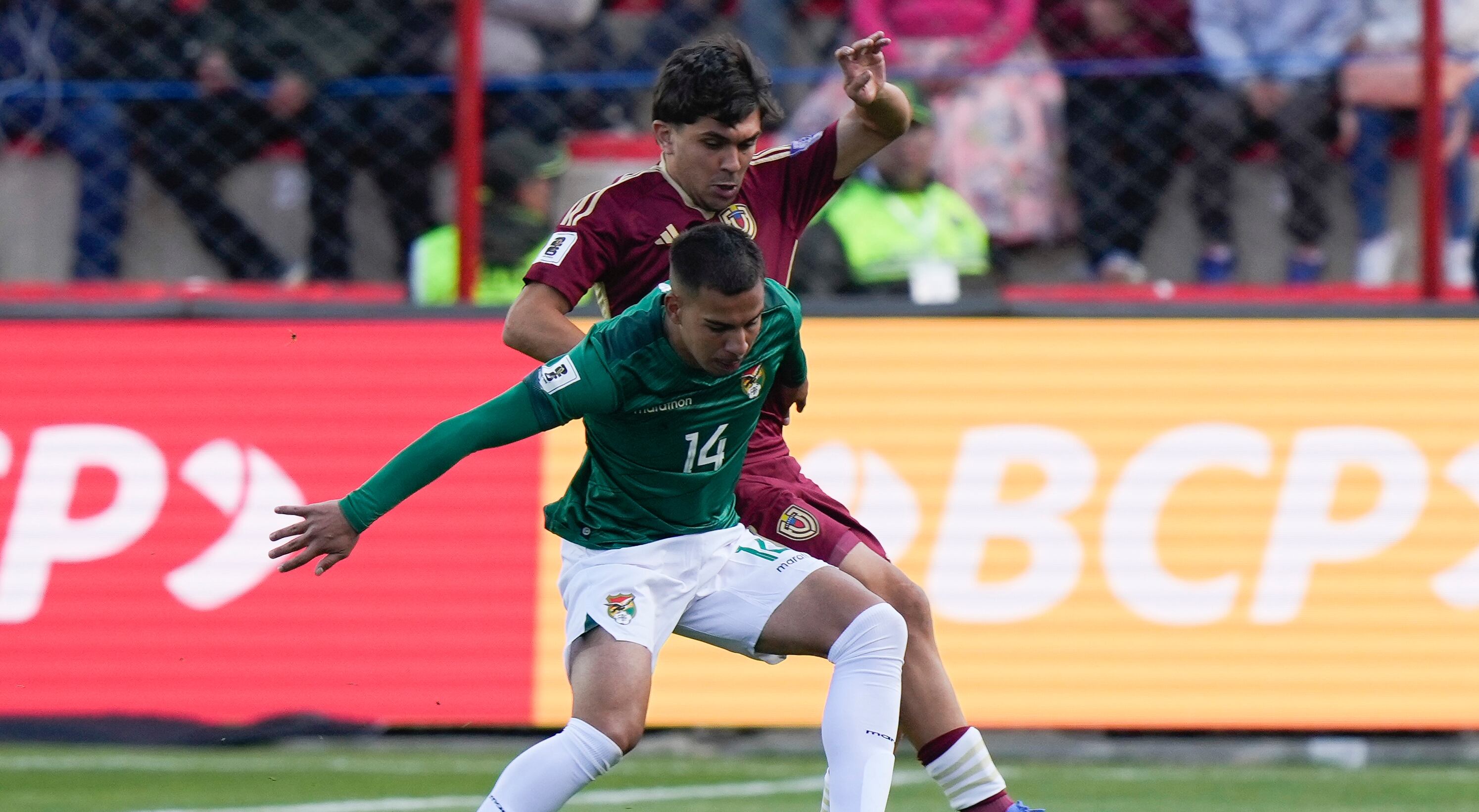 El boliviano Robson Matheus controla el balón desafiado por el venezolano Jon Aramburu durante un partido de clasificación para la Copa Mundial de la FIFA 2026 en el estadio Municipal de Villa Ingenio en El Alto, Bolivia, el jueves 5 de septiembre de 2024. (Foto AP/Juan Karita)