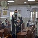 Para evitar el contagio, en algunas sinagogas de la ciudad Bnei Brak han dividido los espacios con plástico.