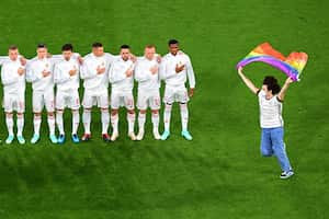 A person waving the rainbow flag runs on the pitch as the Hungary players line up for the national anthems the UEFA EURO 2020 Group F football match between Germany and Hungary at the Allianz Arena in Munich on June 23, 2021. (Photo by Matthias Hangst / POOL / AFP)