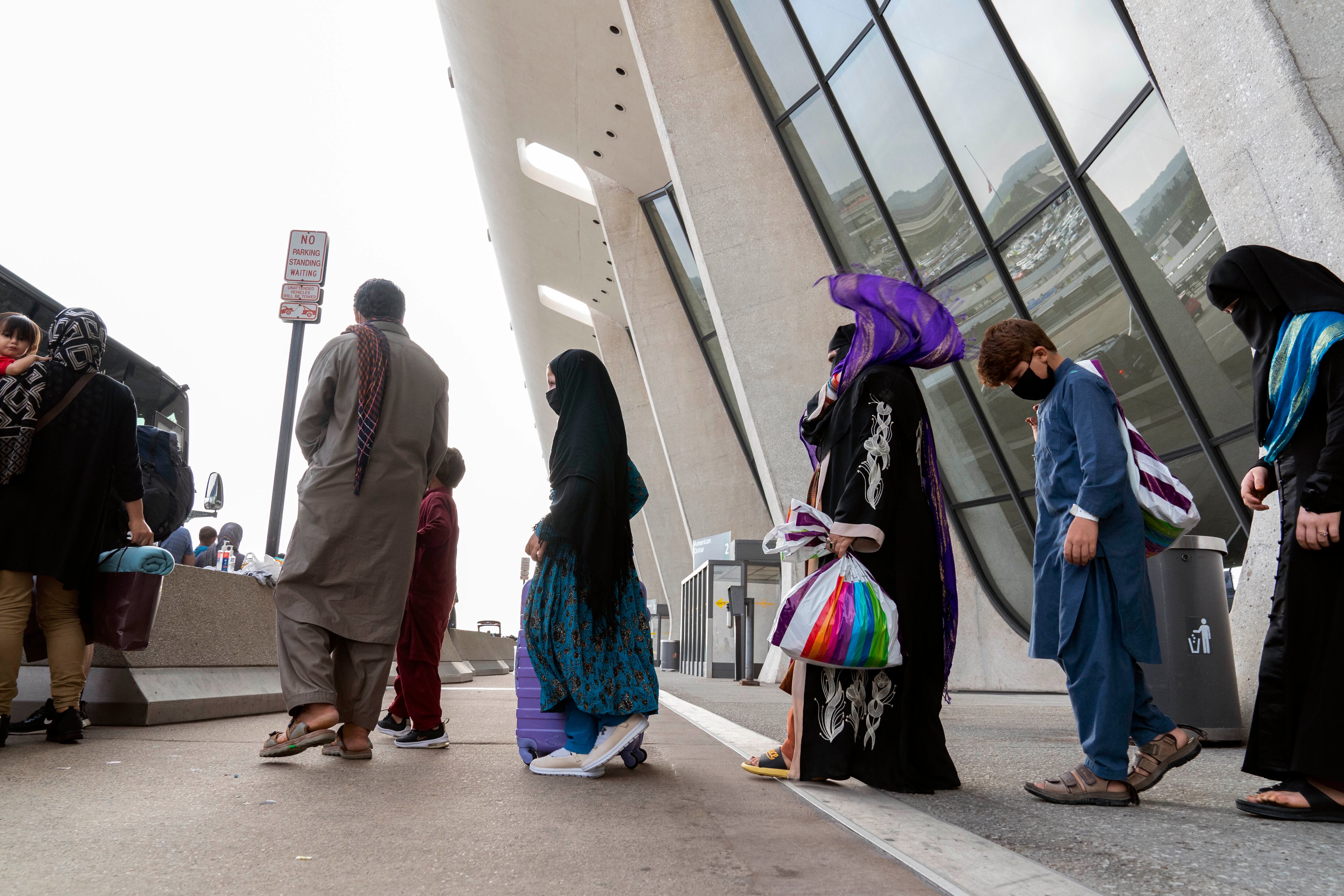 Las personas evacuadas de Kabul, Afganistán, esperan para abordar un autobús después de llegar al Aeropuerto Internacional Washington Dulles, en Chantilly, Virginia, el lunes 30 de agosto de 2021 (AP Photo / Jose Luis Magana).