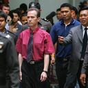 BANGKOK, THAILAND - AUGUST 20: American John Mark Karr (C) is led by Thai police from the immigration detention facility to the airport to depart for the U.S. August 20, 2006 in Bangkok, Thailand. Karr, 41, is a suspect in the 1996 murder of six-year-old JonBenet Ramsey in Boulder, Colorado. According to Thai police, Karr has confessed to the crime, saying Ramsey's death was not intentional. (Photo by Paula Bronstein/Getty Images)