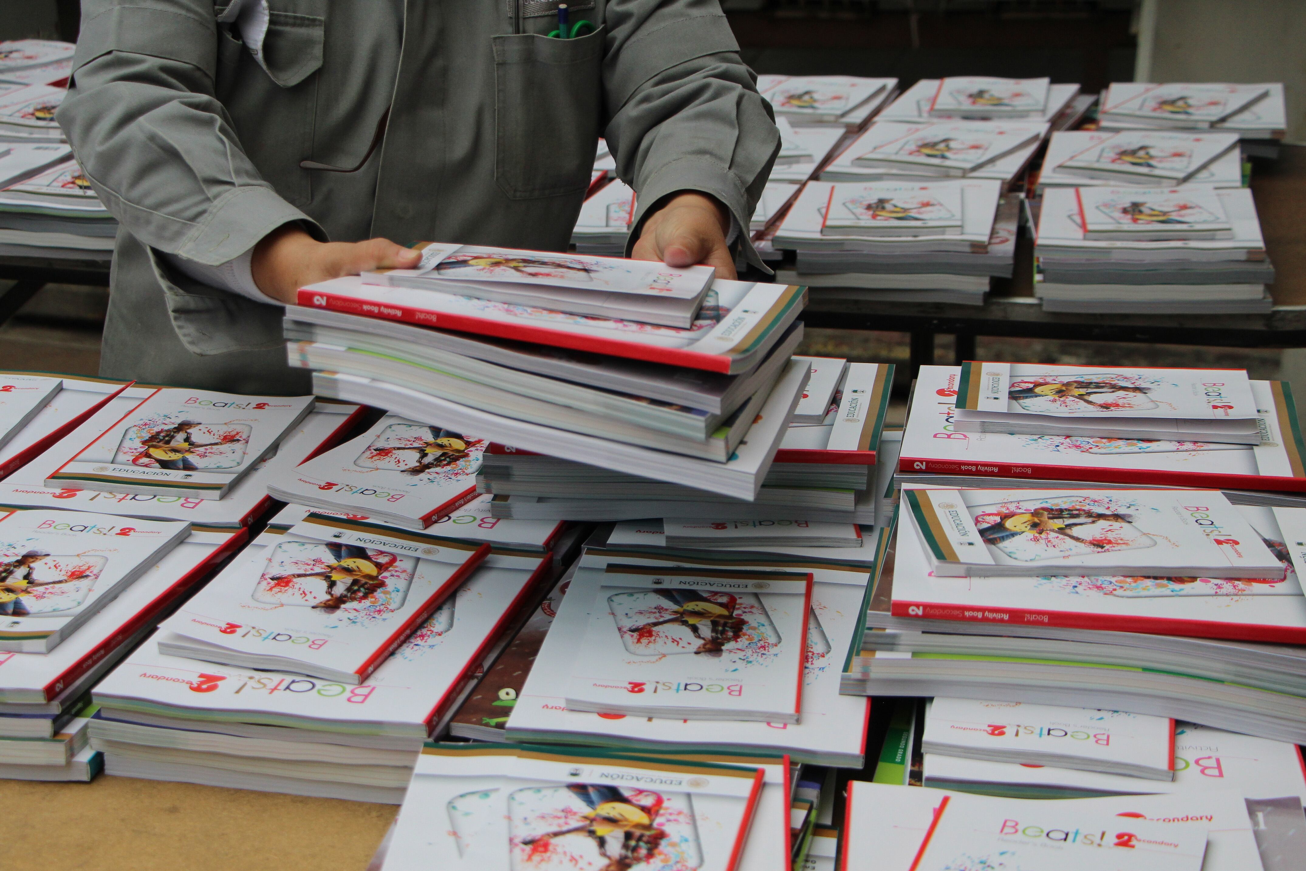 Un trabajador de la educación entrega útiles escolares gratuitos, durante el programa escolar de regreso a la escuela en el 2021.