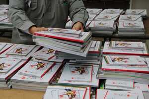 Un trabajador de la educación entrega útiles escolares gratuitos, durante el programa escolar de regreso a la escuela en el 2021.