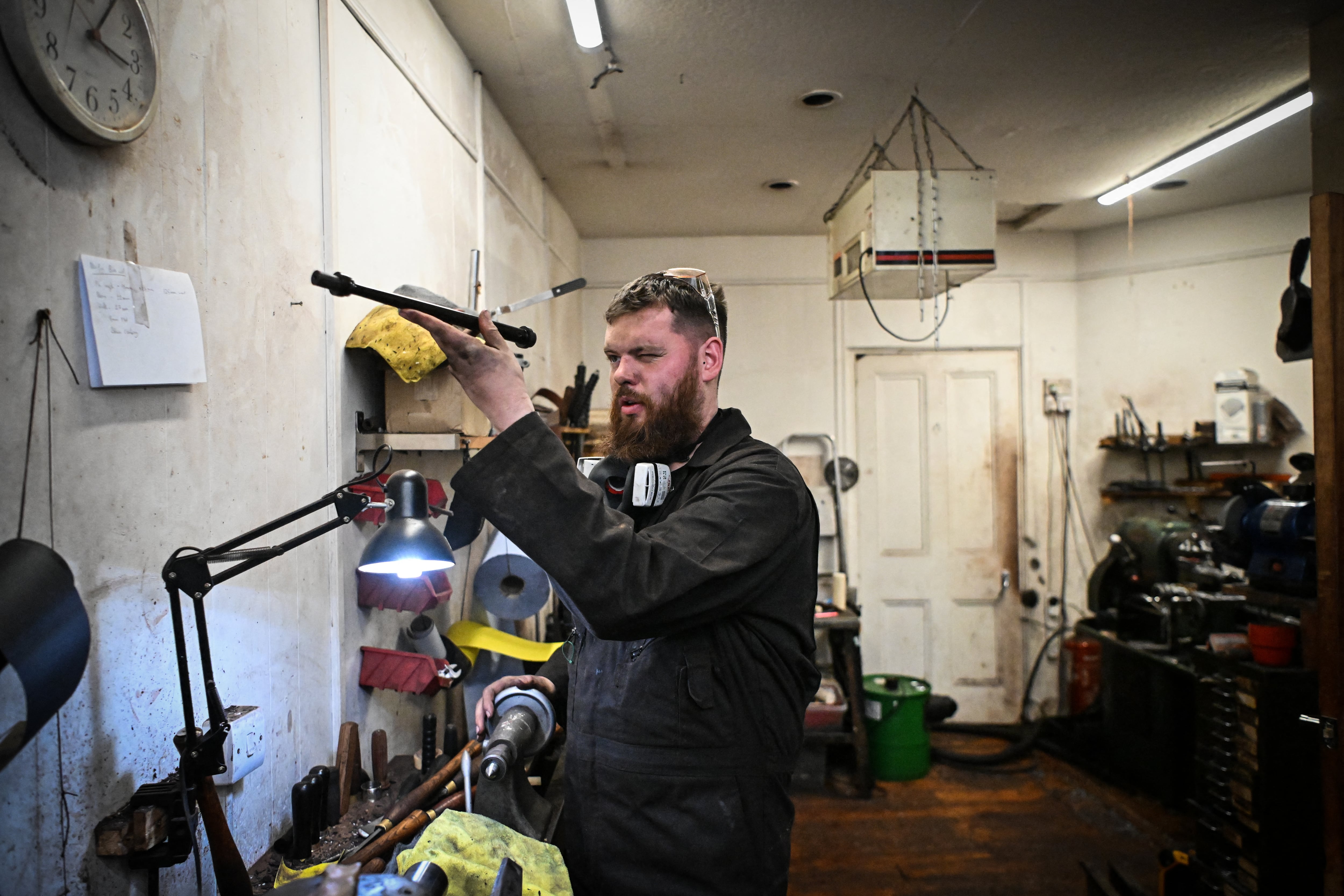 Artisan bagpipe maker Ruari Black, the last traditional bagpipe-makers who make everything by hand from start to finish, works a bagpipe chanter in the workshop of Kilberry Bagpipes in Edinburgh, on October 7, 2024. The Highland bagpipe is an integral part of Scottish culture and history, famous for its distinctive, powerful sound that even accompanied troops as they landed in northern France on D-Day. But the wind instrument is slowly growing silent as demand dwindles and machine-made bagpipes replace traditionally crafted ones, consigning their use to largely ceremonial occasions. Ruari Black is one of only a few remaining craftsmen in Edinburgh who knows how to make the instrument by hand. (Photo by ANDY BUCHANAN / AFP)