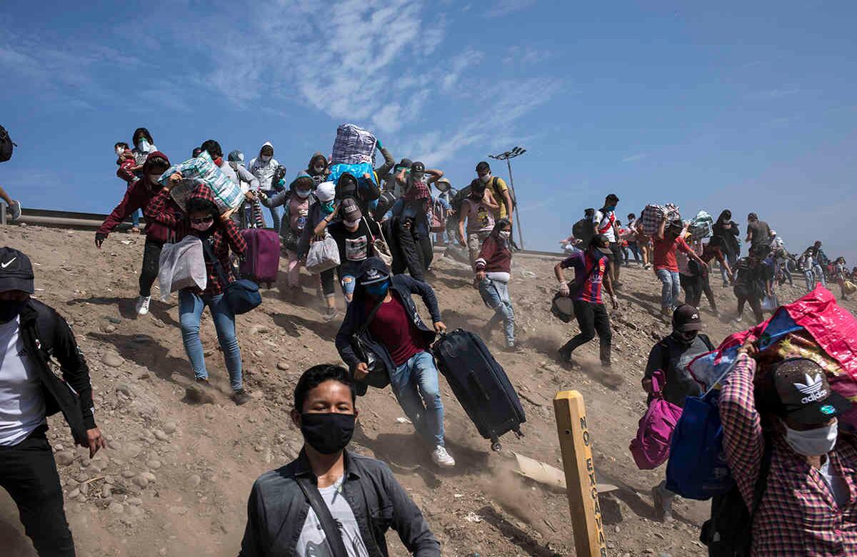 Trabajadores informales peruanos evaden un bloqueo policial en busca de una ruta diferente a casa, en las afueras de Lima. Foto del 18 de abril. Debido a que las estrictas normas de cuarentena no permiten viajar entre provincias, los trabajadores han estado viviendo al lado de la carretera.  Foto: Rodrigo Abd / AP