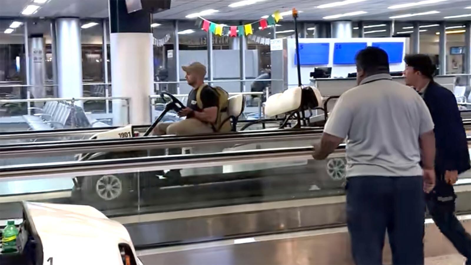 Pasajeros en el aeropuerto de Buffalo mirando a un hombre conduciendo un carrito eléctrico de forma peligrosa