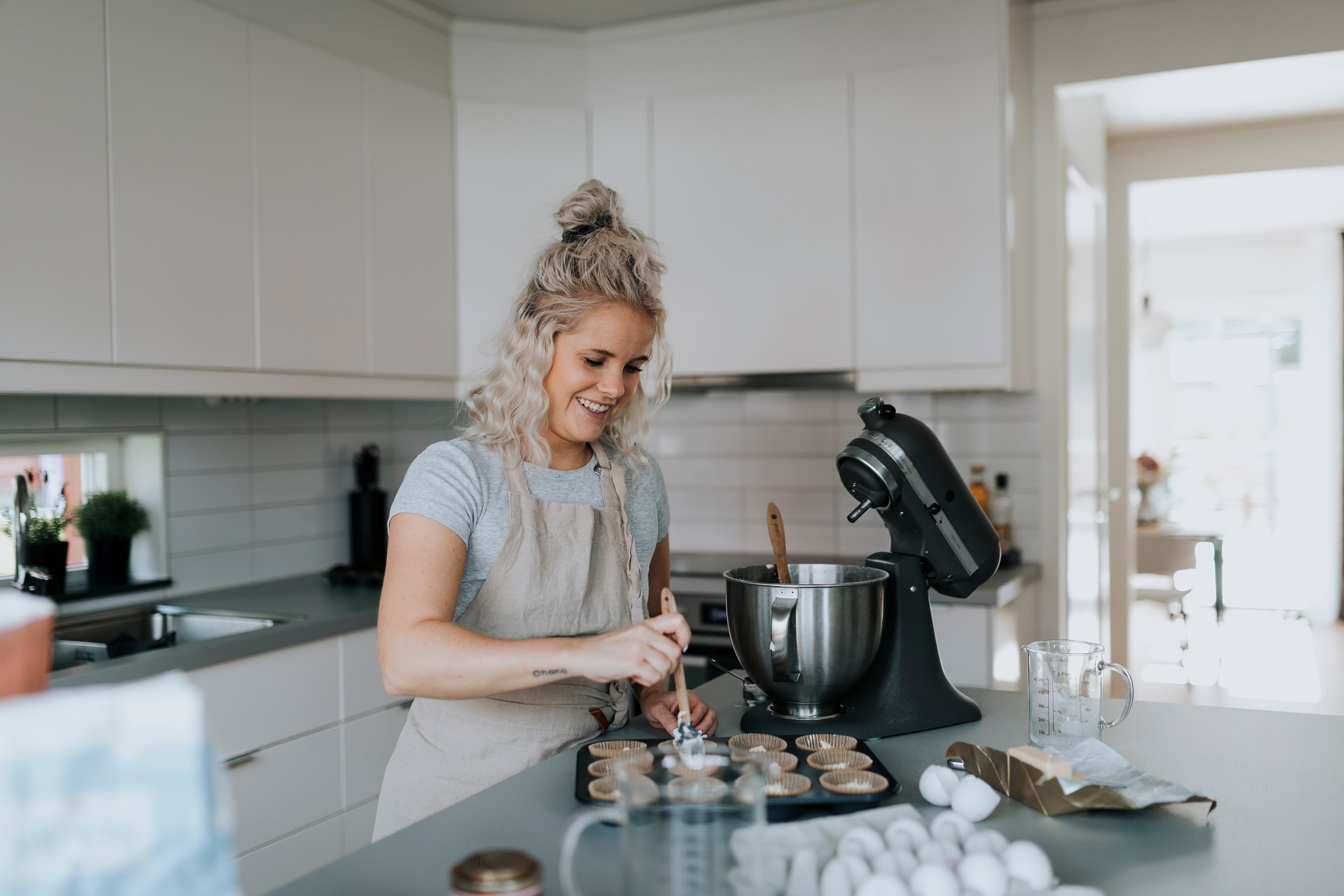 Imagen de mujer cocinando con batidora eléctrica.