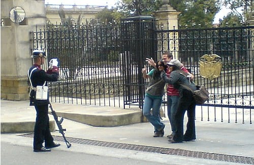 Disciplina / Aficionado
Mientras en la mayoría de países la gente se para al lado de los guardias presidenciales para tomarse fotos, y ellos no se mueven por nada del mundo, unos turistas logran sacar de su puesto a un guardia de la Casa de Nariño para que llevarse un recuerdo. 
