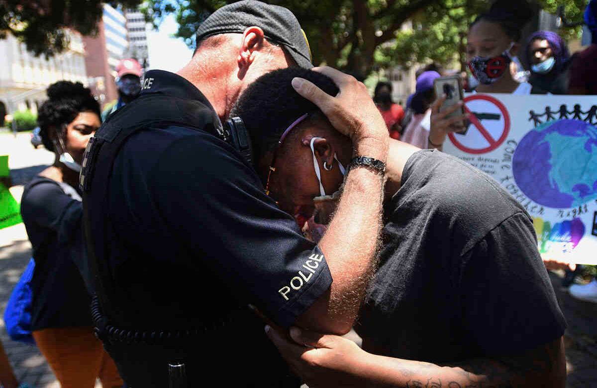  Un oficial de policía y un manifestante se abrazan cuando la gente se reúne en Shreveport, Luisiana, el domingo 31 de mayo de 2020. Marcharon al juzgado de la parroquia de Caddo bajo la consigna “Black Lives Matter”: las vidas negras importan. Foto: Henrietta Wildsmith / The Shreveport Times a través de AP.
