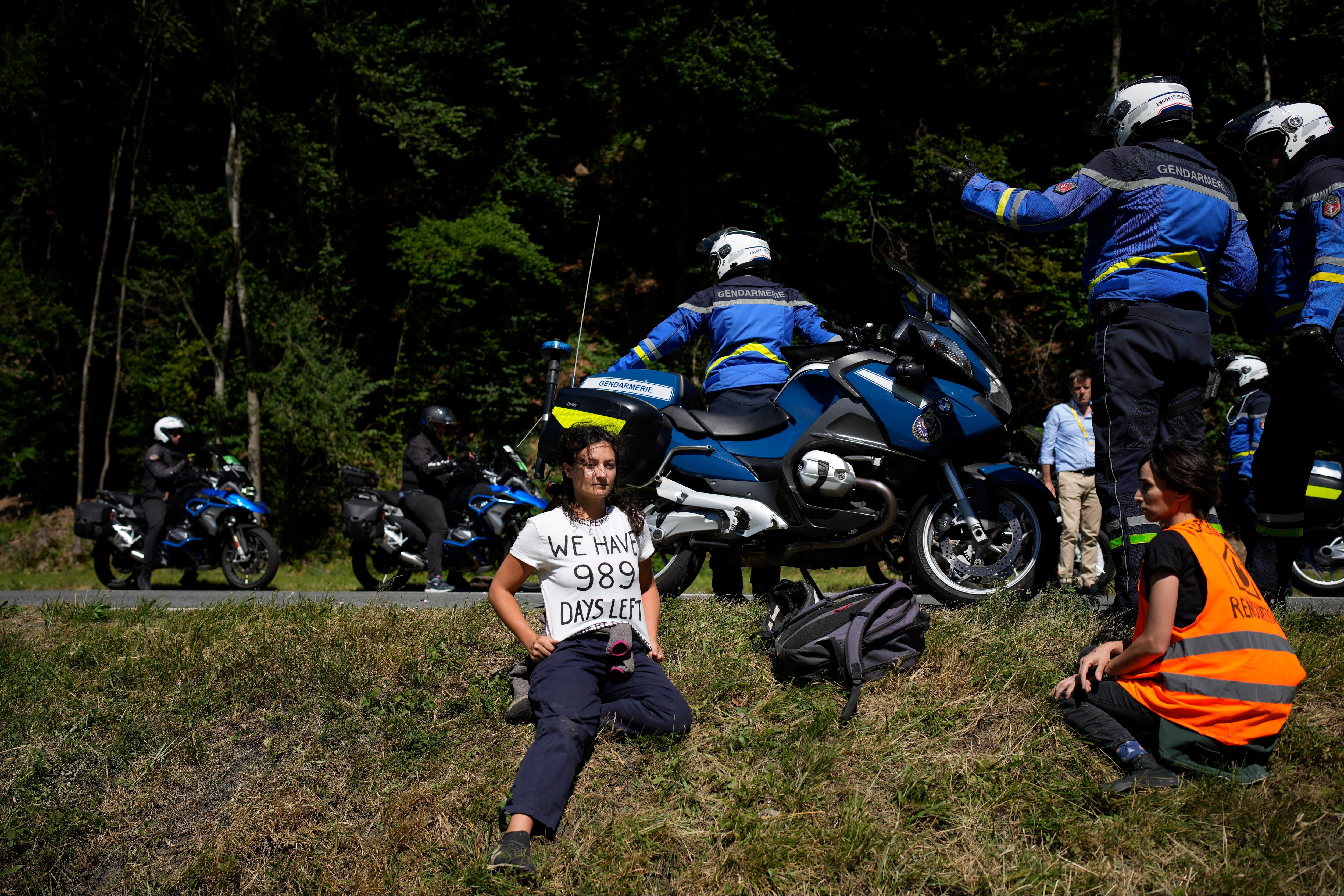 French gendarmes secure the road after climate activits demonstrators stopped the race during the tenth stage of the Tour de France cycling race over 148.5 kilometers (92.3 miles) with start in Morzine les Portes du Soleil and finish in Megeve, France, Tuesday, July 12, 2022. (AP Photo/Daniel Cole)