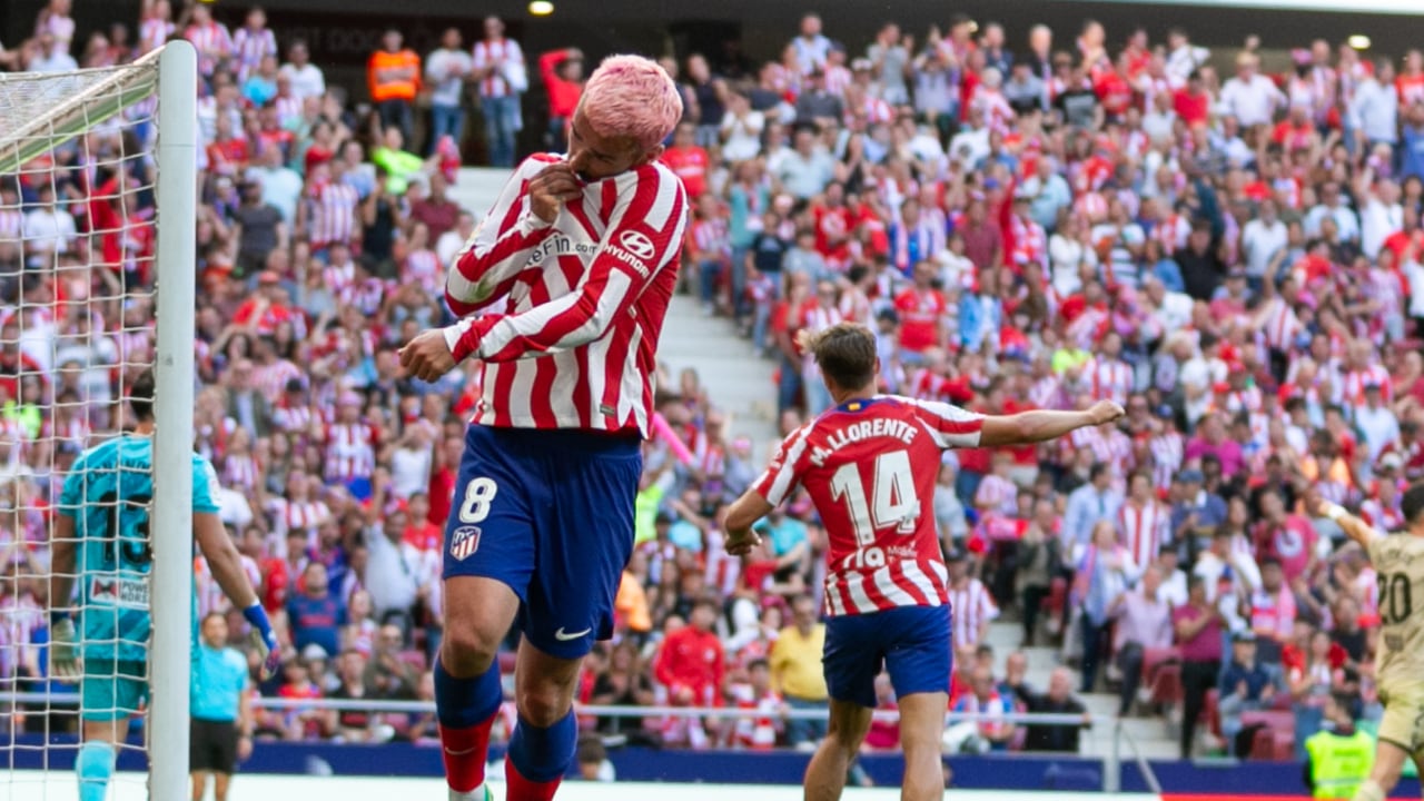 Antoine Griezmann besando el escudo del Atlético de Madrid.