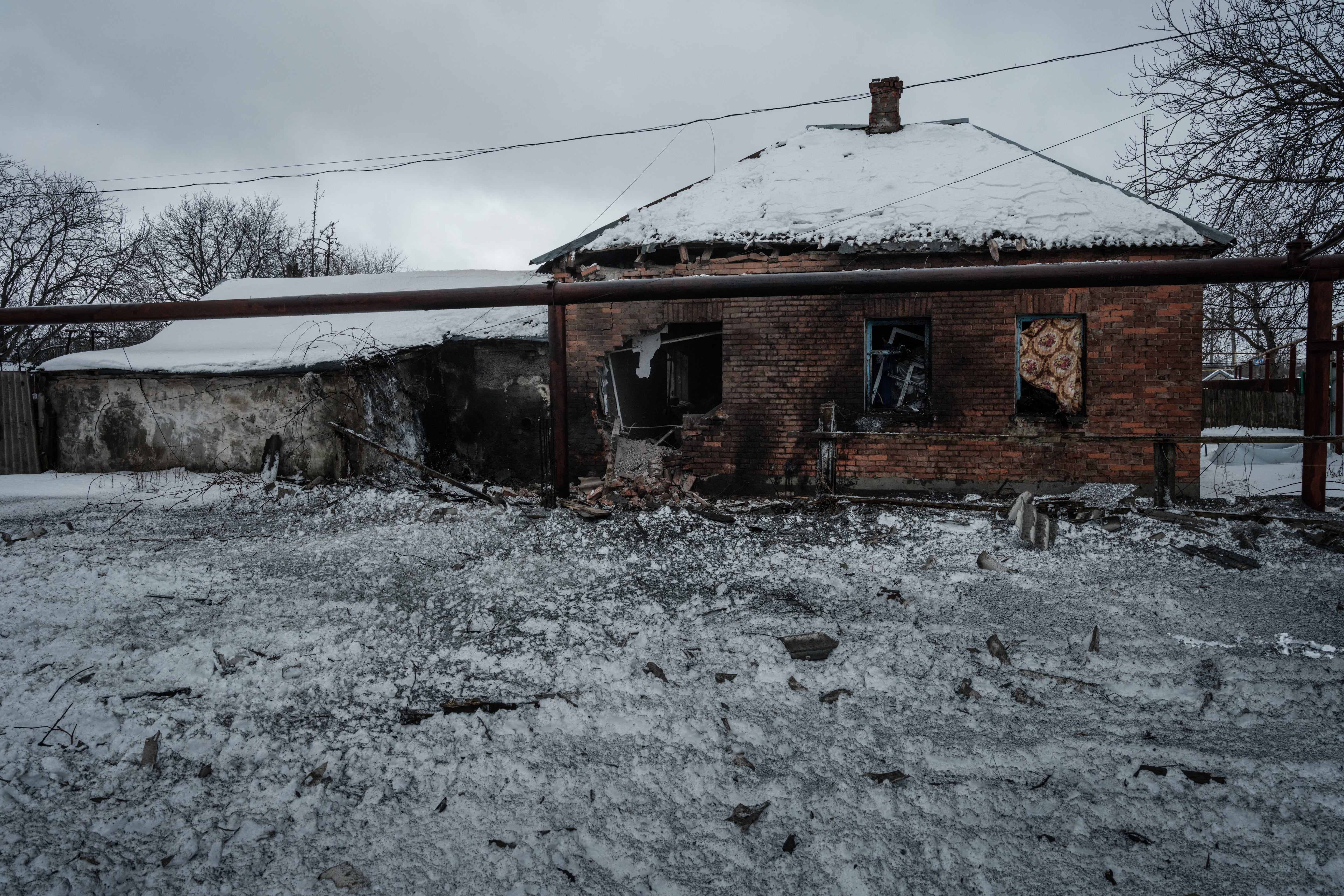 Una casa destruida por los bombardeos está cubierta de nieve en Chasiv Yar el 14 de febrero de 2023, en medio de la invasión rusa de Ucrania. (Foto de YASUYOSHI CHIBA / AFP)