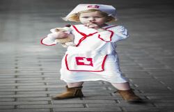 Una niña vestida de enfermera, a la espera de entrar en la sala de operaciones del hospital "Teddy Bear", sostiene un oso de peluche en el hospital de niños en Utrecht, Holanda. (EFE)