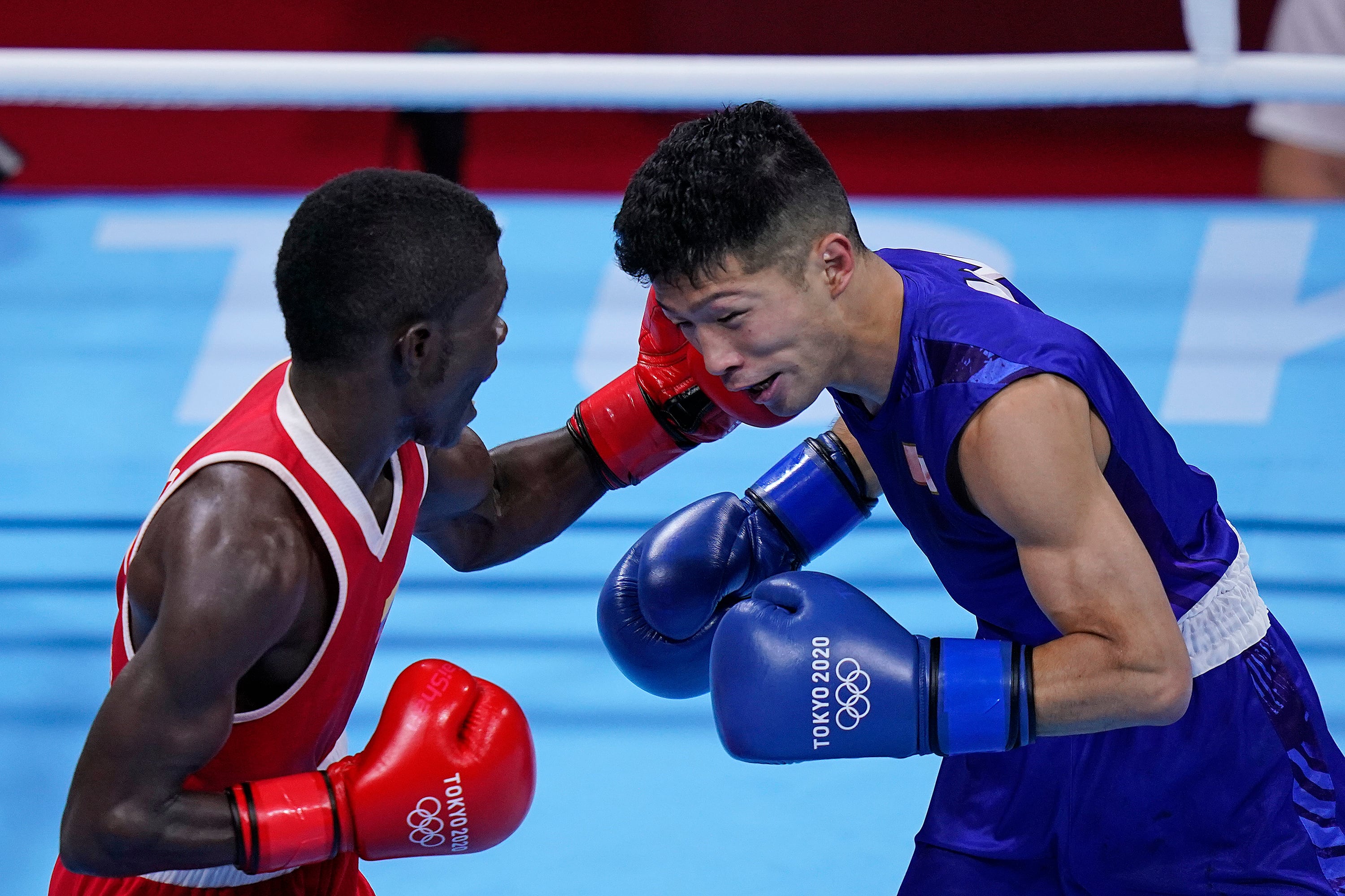 Colombia's Yuberjen Herney Martinez Rivas, right, exchanges punches with Japan's Ryomei Tanaka in their men's flyweight 52-kg quarterfinal boxing match at the 2020 Summer Olympics, Tuesday, Aug. 3, 2021, in Tokyo, Japan. (AP Photo/Themba Hadebe)