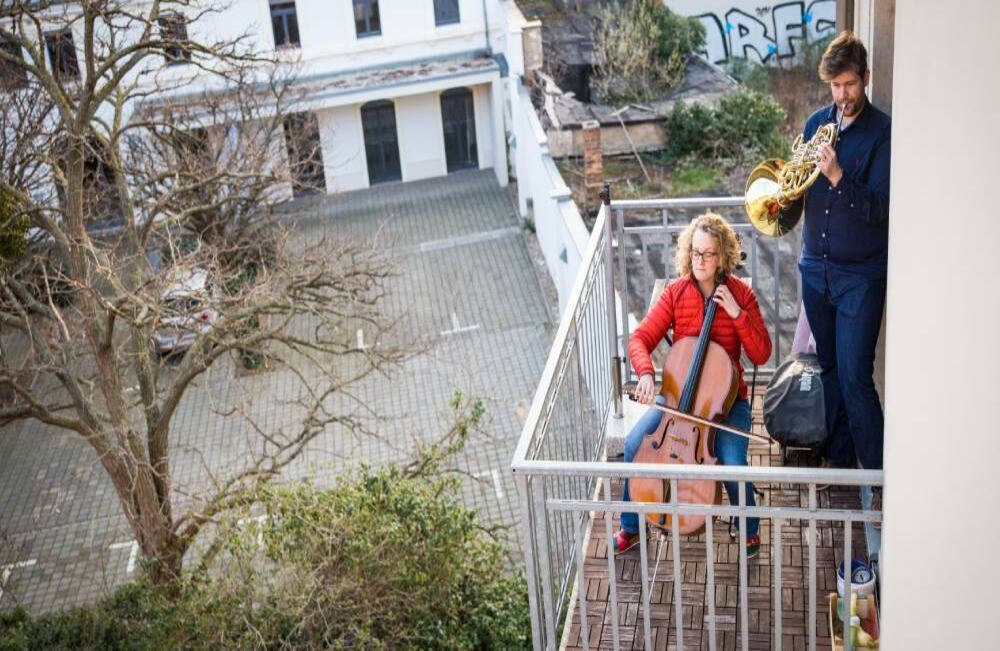 Karoline Strobl y Zoltan Macsai interpretan la "Oda a la Alegría" de Beethoven desde su balcón en Dresden, Alemania oriental, en una acción coordinada para mostrar un signo de solidaridad durante la nueva pandemia de coronavirus Foto: Oliver Killig / dpa / AFP