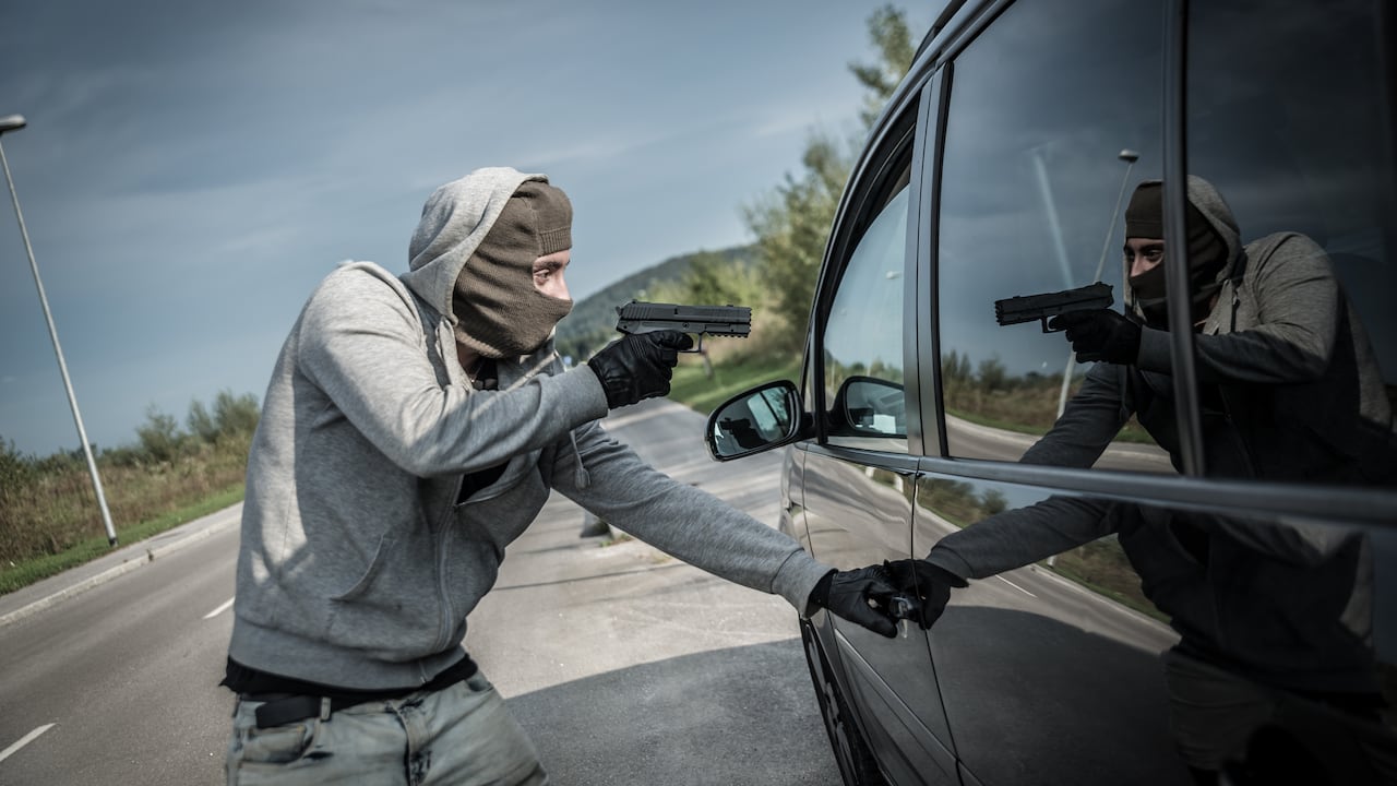 Una persona apunta al interior del coche. Robo Carro