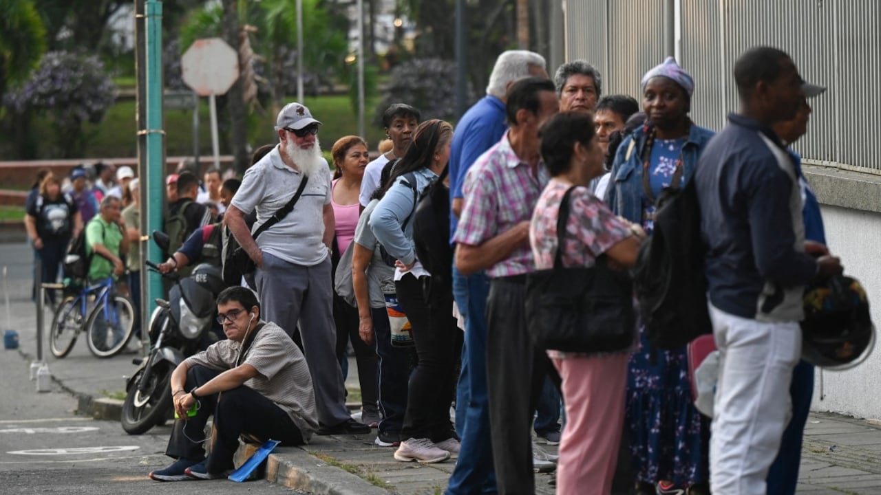 La gente hace cola frente a una farmacia para reclamar medicamentos en Cali, Colombia, el 25 de marzo de 2025 (Foto de JOAQUÍN SARMIENTO / AFP)