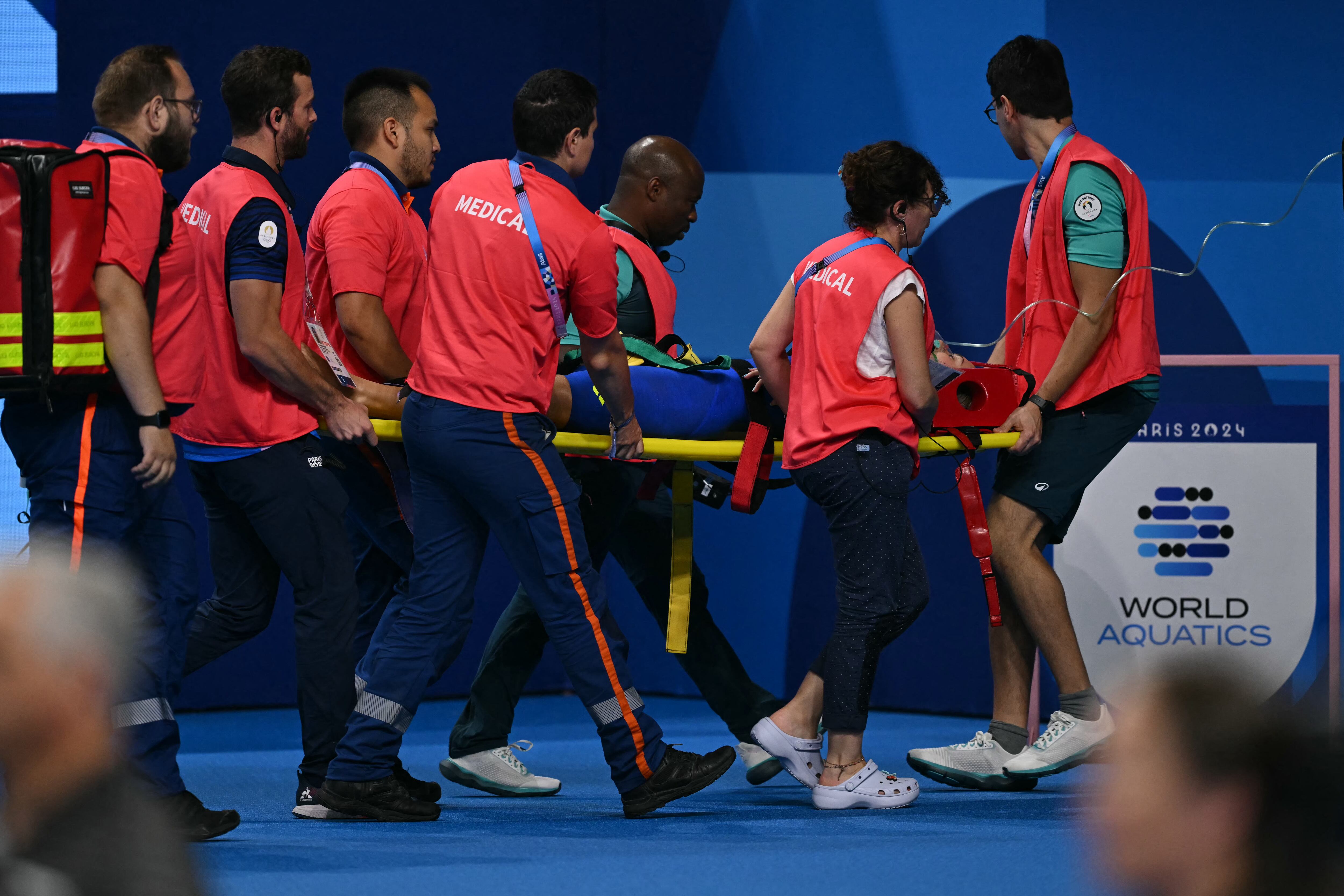 Medical staff carry Slovakia's Tamara Potocka on a stretcher after she collapsed following a heat of the women's 200m individual medley swimming event during the Paris 2024 Olympic Games at the Paris La Defense Arena in Nanterre, west of Paris, on August 2, 2024. (Photo by Jonathan NACKSTRAND / AFP)