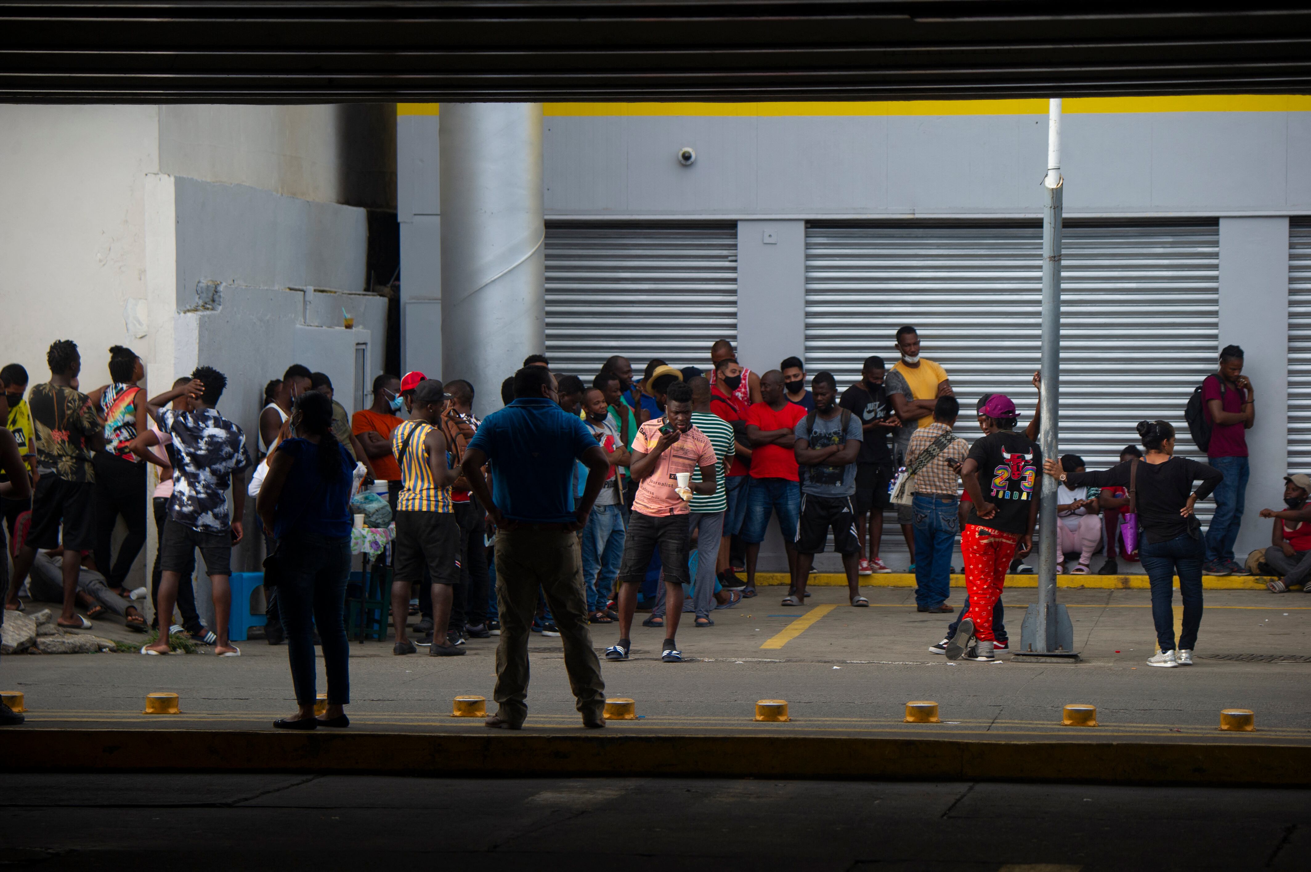 Haitian and Central American migrants wait for remittance banks to open to withdraw money sent by their relatives in Tapachula, Chiapas state, Mexico, on September 14, 2021. - Tens of thousands of US-bound migrants stranded in an overcrowded city in southern Mexico are desperate to escape what they say feels like a huge open-air prison. (Photo by CLAUDIO CRUZ / AFP)