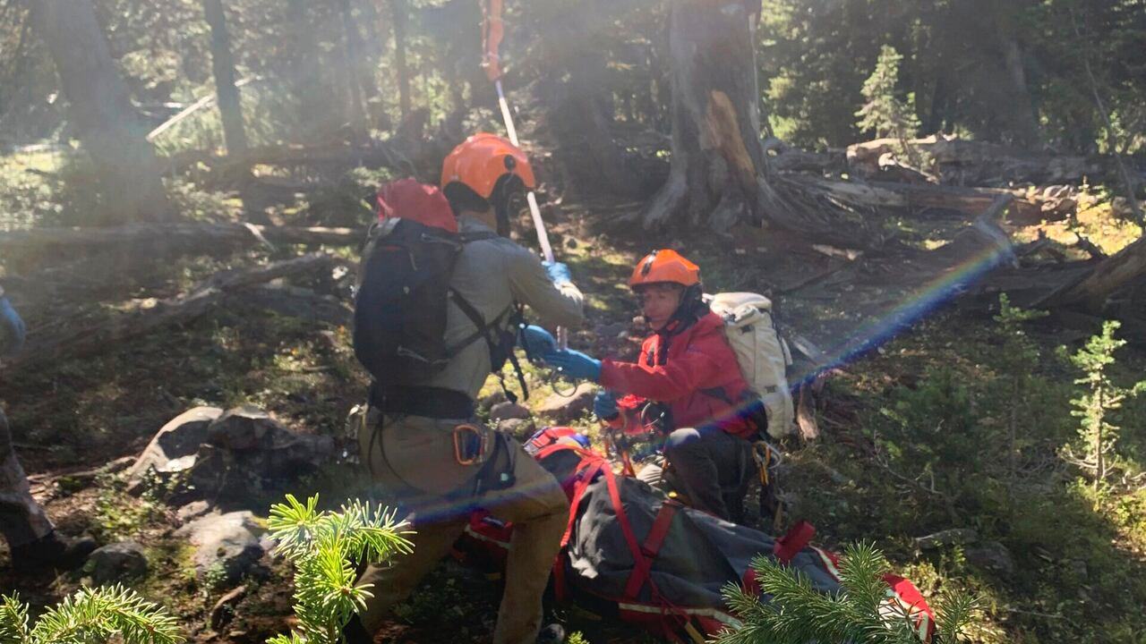 En esta fotografía proporcionada por el Sheriff Search and Rescue del condado de Gallatin, Montana, los miembros del equipo de búsqueda y rescate enganchan una cuerda que cuelga de un helicóptero de rescate a una canasta que sostiene a Rudy Noorlander después de que Noorlander fuera mutilado por un oso grizzly que le mordió el mandíbula inferior, viernes 8 de septiembre de 2023