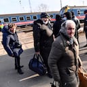 Ukrainian people leave a train that carried 275 people, to arrive in Zahony, Hungary, a border town with Ukraine, Friday, Feb. 25, 2022. Thousands of Ukrainians are fleeing from war by crossing their borders to the west in search of safety. They left their country as Russia pounded their capital and other cities with airstrikes for a second day on Friday. (AP Photo/Anna Szilagyi)