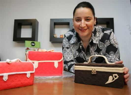 Carolina Montoya, posa junto a una torta con forma de bolso diseñada por ella.  "Empecé en un cumpleaños de mi esposo, investigué los materiales y me dije: me voy a lanzar", dijo.