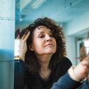 Mirror image of a pensive senior woman looking at her aging face with a little sadness.