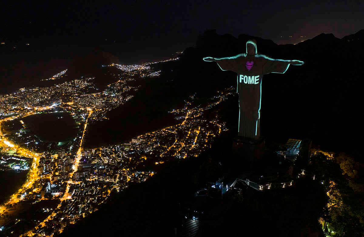 La palabra portuguesa "hambre" se proyecta sobre la estatua de Cristo Redentor en medio del nuevo brote de coronavirus en Río de Janeiro, Brasil, el 10 de mayo. El hambre en Brasil crece día a día por la crisis económica acrecentada por la pandemia. Foto: Leo Correa/ AP. 