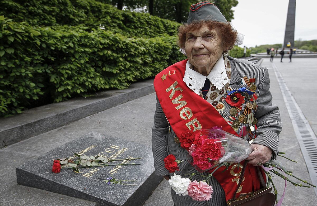 Ivanchenko Emilia, veterana ucraniana de la Segunda Guerra Mundial, camina con un ramo de flores cerca de la Tumba del Soldado Desconocido en Kiev, Ucrania. (EFE/Roman Pilipey)