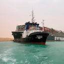 En esta imagen publicada por la Autoridad del Canal de Suez, un barco navega ante un enorme carguero llamado Ever Green, varado el miércoles 24 de marzo de 2021 tras quedarse atravesado en el Canal de Suez, Egipto, y bloquear un paso marítimo crucial para el tráfico global de mercancías. (Autoridad del Canal de Suez via AP)