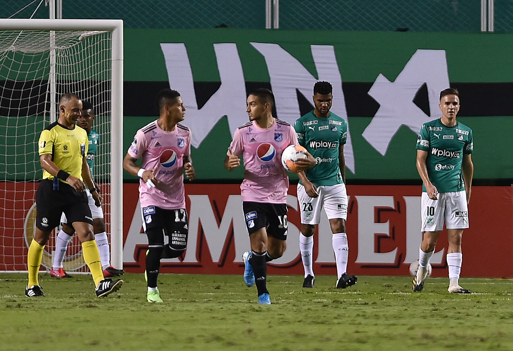 El colombiano Millonarios Ayron del Valle (2-L) y el colombiano Millonarios Cristian Arango (C) reaccionan después del gol en propia meta del Deportivo Cali de Colombia durante su partido de fútbol de la segunda ronda de la Copa Sudamericana a puertas cerradas en el estadio Deportivo Cali en Cali, Colombia, el 4 de noviembre de 2020, en medio de la nueva pandemia de coronavirus COVID-19. (Foto por Luis ROBAYO / PISCINA / AFP)