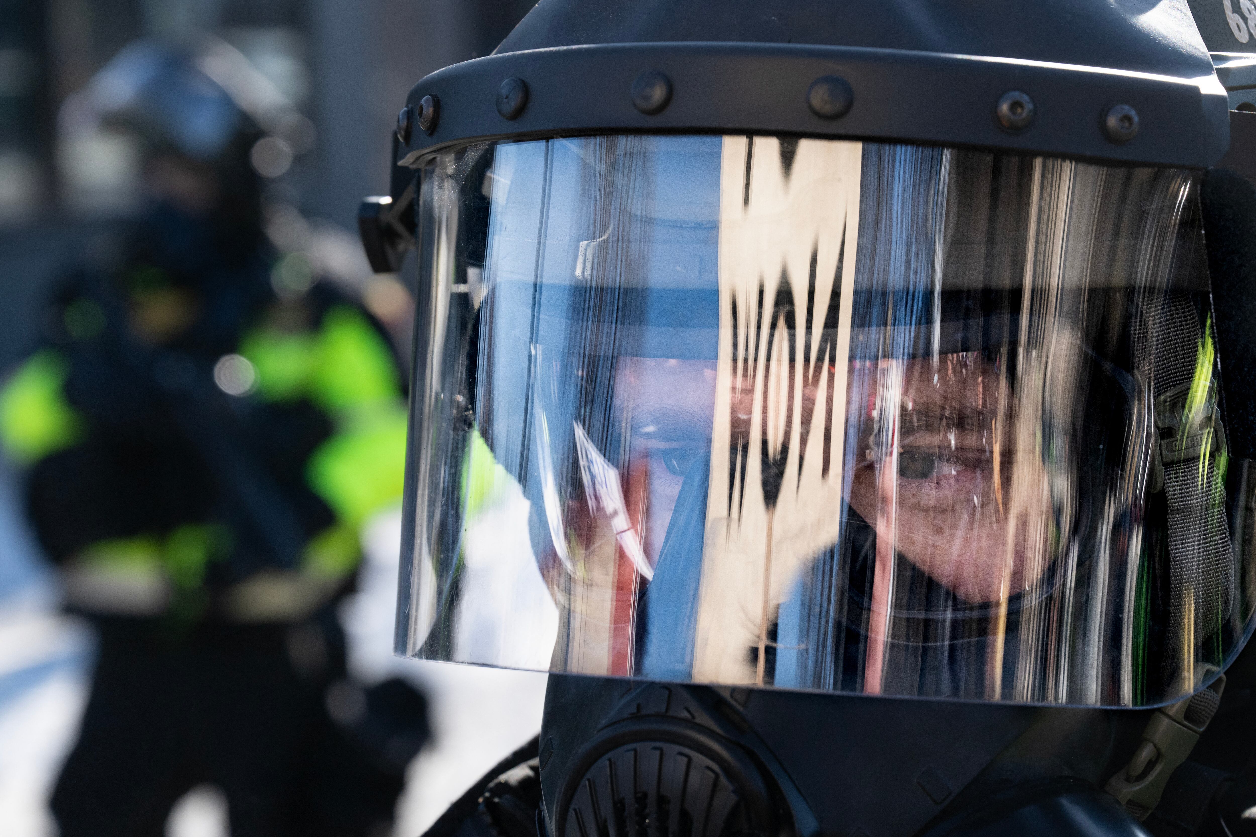 Minnesota Department of Natural Resources Conservation Officers stand guard as demonstrators gather near the site of where state and local authorities say a man was shot and killed by federal agents earlier in the morning in Minneapolis, Minnesota, on January 24, 2026. Federal immigration agents shot dead a man in Minneapolis on Saturday, officials said -- the second fatal shooting of a civilian in the city, sparking fresh protests and outrage from state officials. The death came less than three weeks after US citizen Renee Good was shot and killed by an Immigration and Customs Enforcement officer involved in sweeps to round up undocumented migrants. (Photo by ROBERTO SCHMIDT / AFP)
