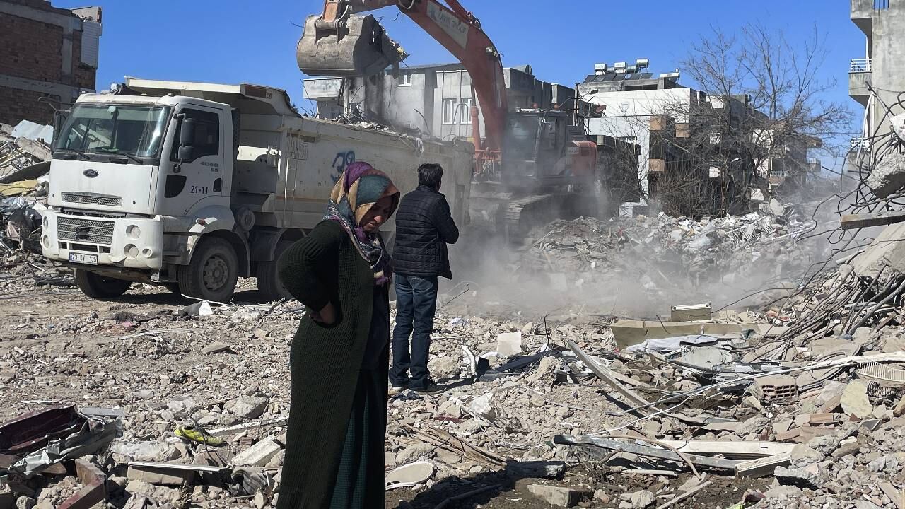 Los padres de Taha Erdem, la madre Zeliha Erdem, a la izquierda, y el padre, Ali Erdem, junto a los escombros del edificio donde Tahan quedó atrapado después del terremoto del 6 de febrero en Adiyaman, Turquía.