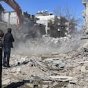 Los padres de Taha Erdem, la madre Zeliha Erdem, a la izquierda, y el padre, Ali Erdem, junto a los escombros del edificio donde Tahan quedó atrapado después del terremoto del 6 de febrero en Adiyaman, Turquía.