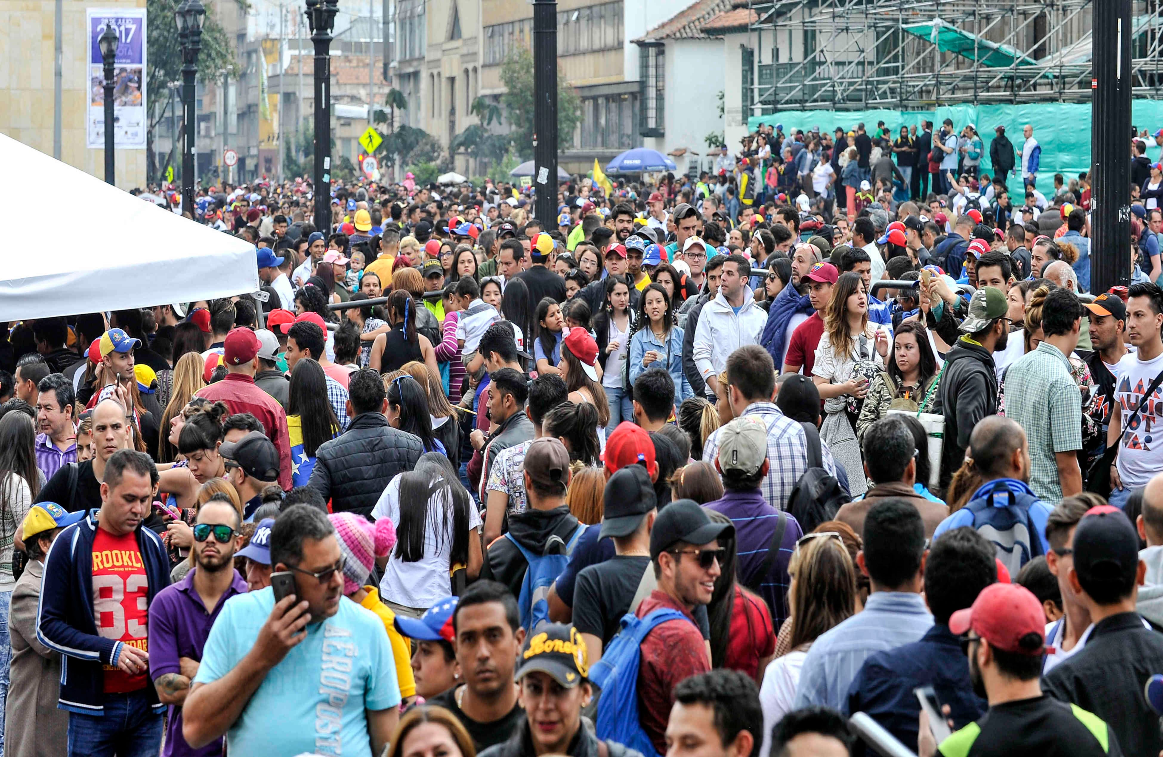 . Miles de venezolanos —residentes en Bogotá— llegan a la Plaza de Bolívar para sufragar, el domingo 16 de julio de 2017, en Colombia, durante las votaciones al plebiscito. Esta jornada democrática ha sido  impulsada  por la oposición al gobierno de Nicolás Maduro. En las tarjetas, los ciudadanos deben responder ‘sí’ o ‘no’ a tres preguntas: la primera es si respalda el plan del presidente Nicolás Maduro de cambiar la Constitución; la segunda es si  apoya la intervención de las Fuerzas Armadas para “restituir el orden constitucional” y por último si desea un gobierno de unidad nacional. Foto: Carlos Julio Martínez / SEMANA