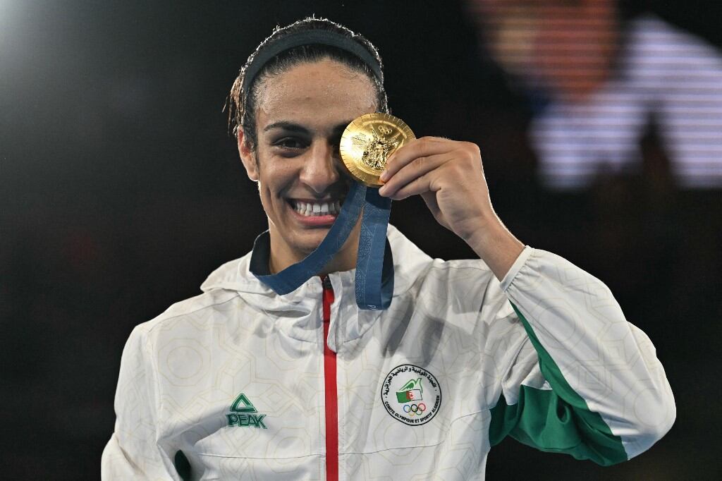 Imane Khelif, medallista de oro de Argelia, posa en el podio durante la ceremonia de entrega de medallas en la categoría final de boxeo femenino de 66 kg durante los Juegos Olímpicos de París 2024 en el estadio Roland-Garros, en París, el 9 de agosto de 2024 (Foto de MOHD RASFAN / AFP)
