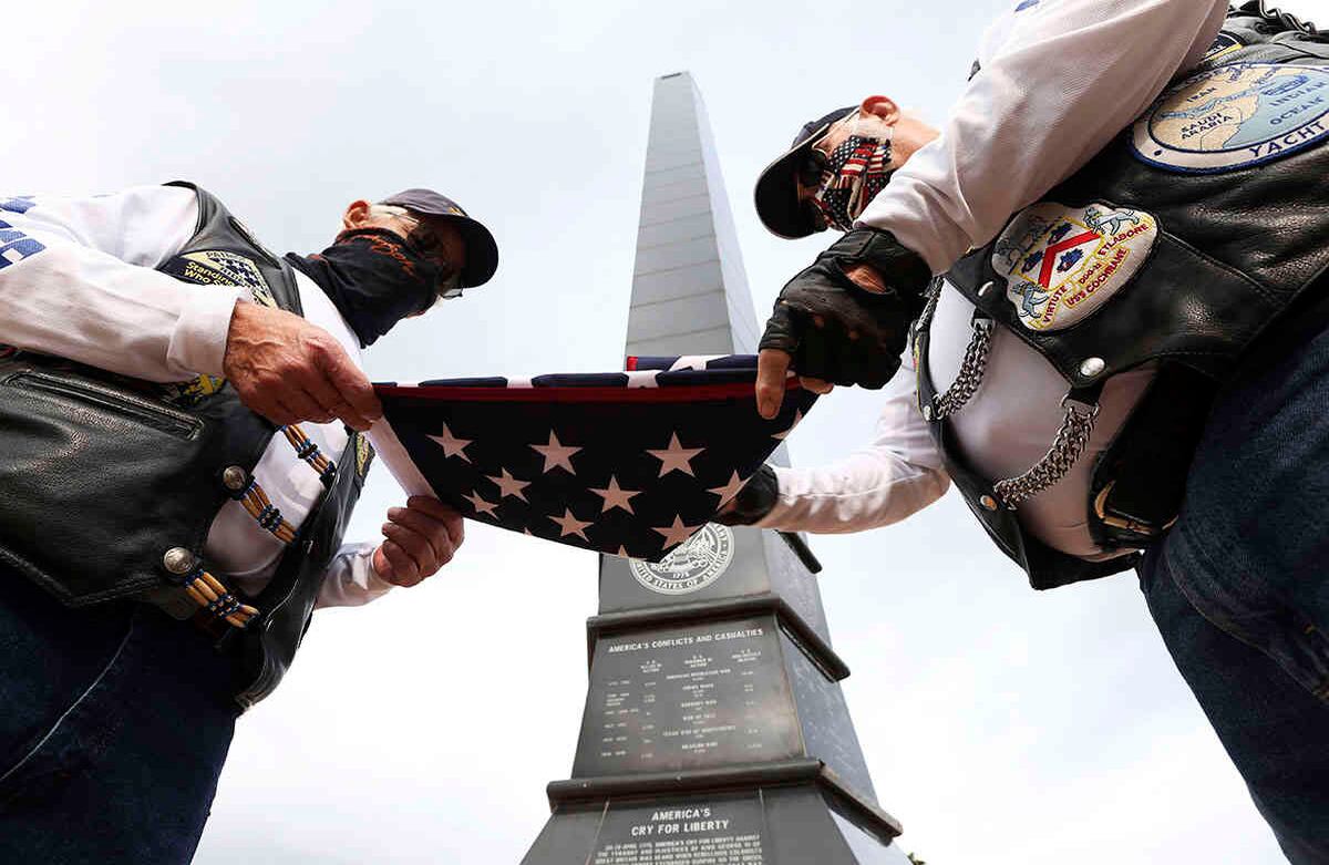 Lee Blunt y Hal Jones doblan una bandera estadounidense después de las ceremonias del Día de los Caídos en el American Spire Plaza of Honor en McAllen, Texas, el lunes 25 de mayo de 2020. (Delcia Lopez / The Monitor vía AP)