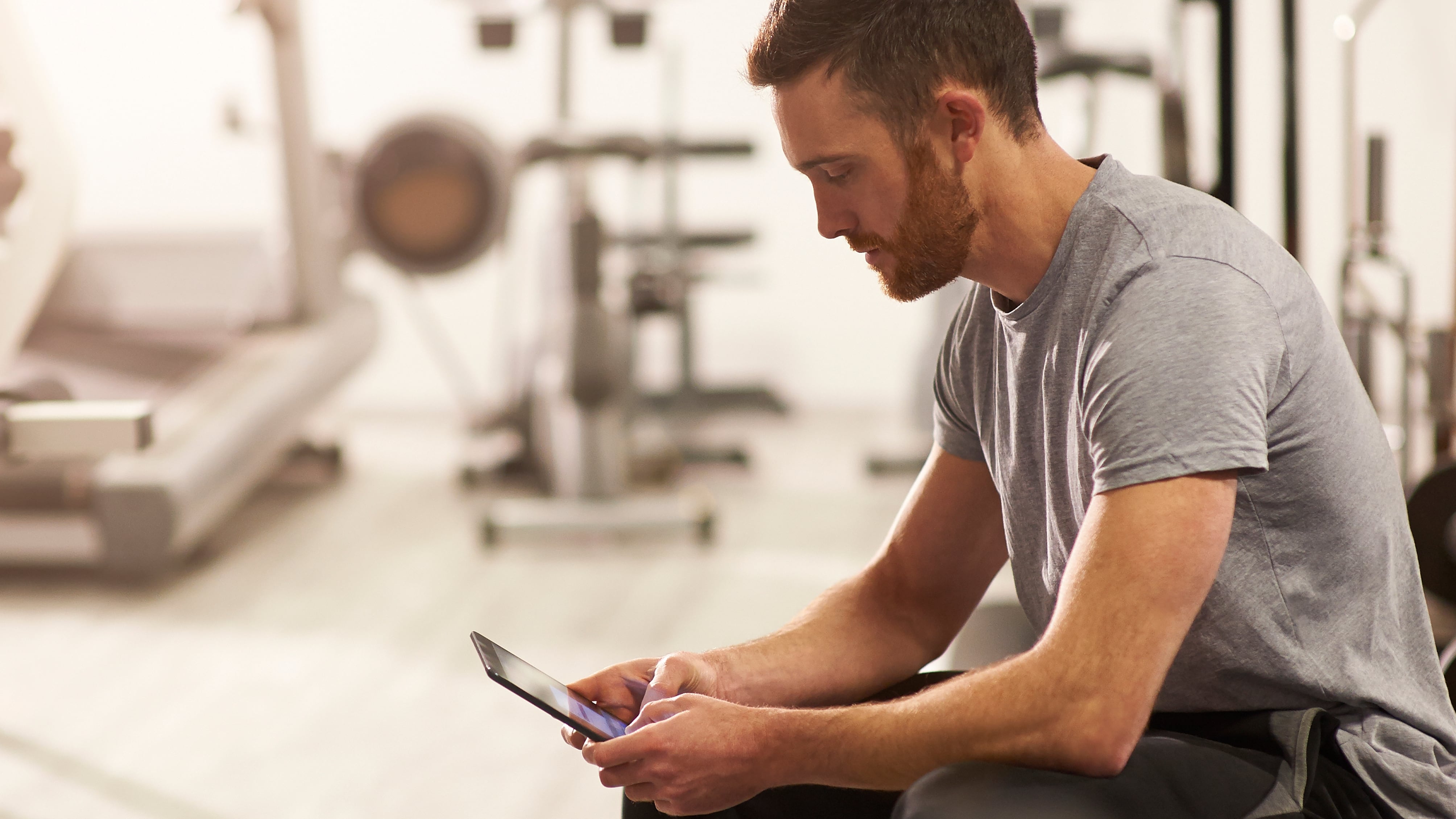 Hombre usando su celular en el gimnasio