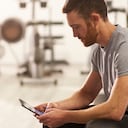 Hombre usando su celular en el gimnasio